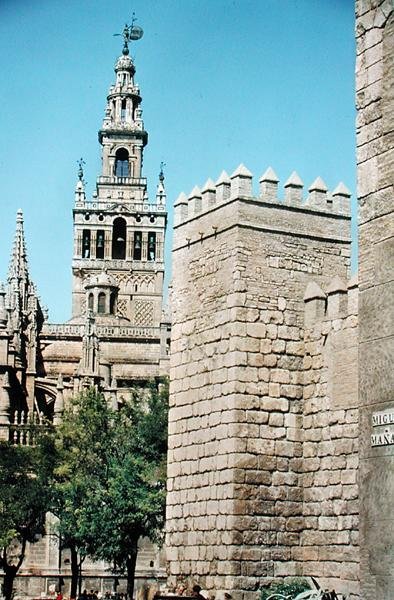 Utsikt over La Giralda-tårnet og et av tårnene i Reales Alcazares av Spanish School
