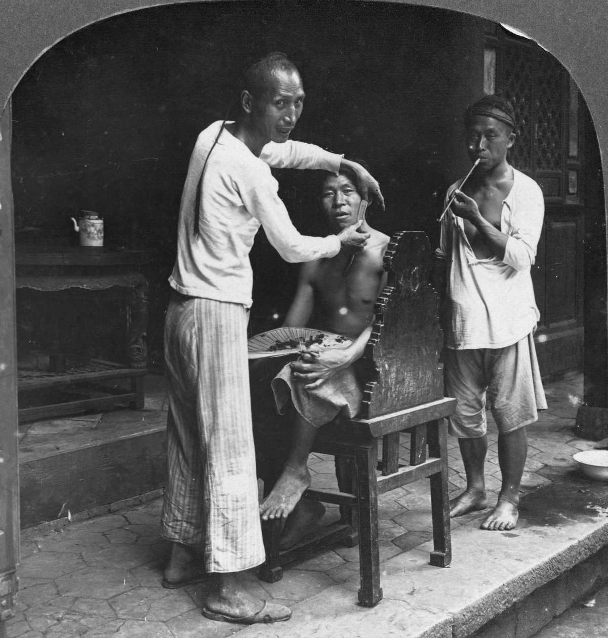 En kinesisk frisør i Bhamo, Burma, 1908 av Stereo Travel Co