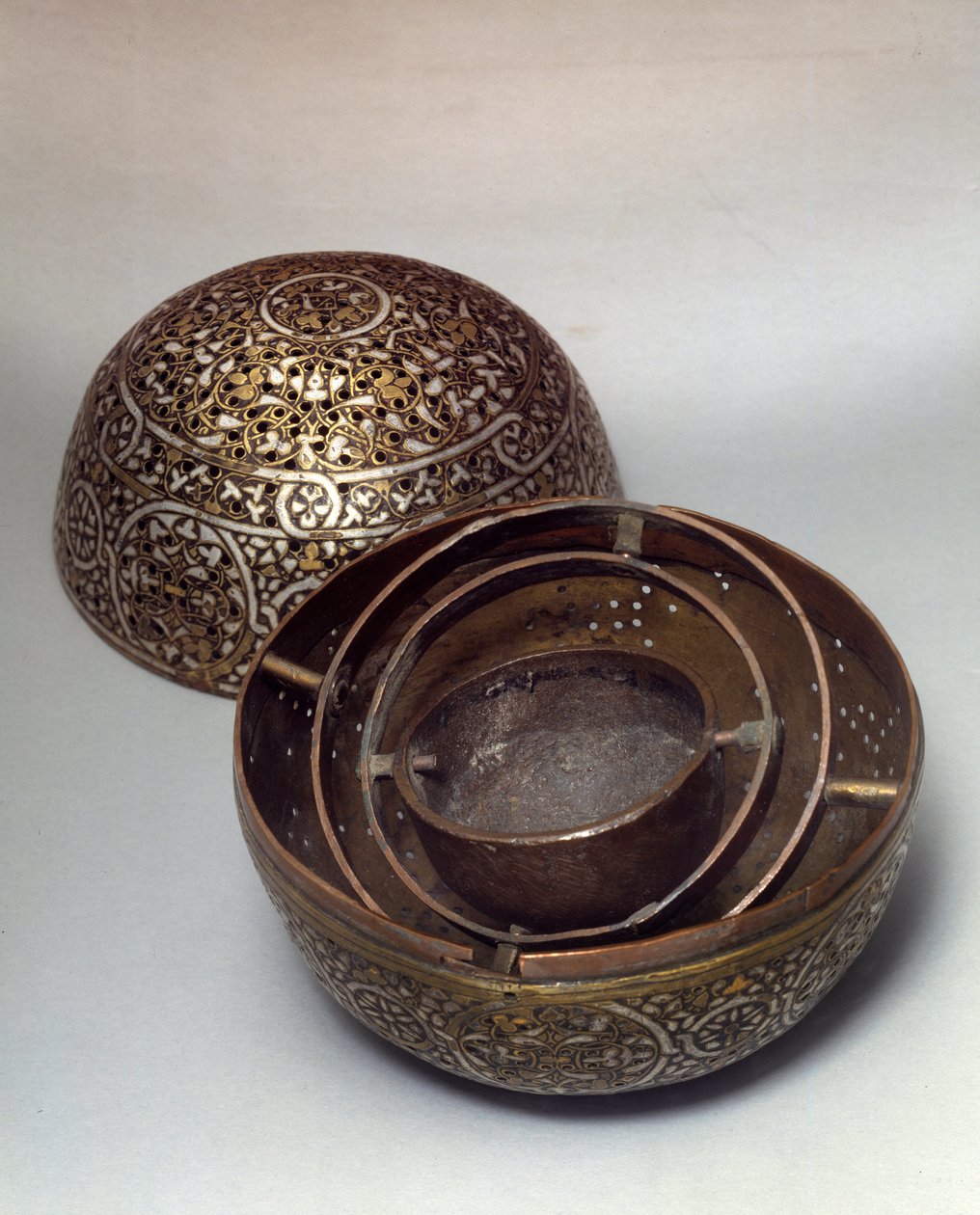 Orientalsk kunst: Burle-parfyme (brenn-parfymer) eller håndvarmer (håndvarmer) fra Syria, sent på 1400-tallet, begynnelsen av 1500-tallet. Kobberlegering hamret med gravdekor, pierces, innlagt med gull, sølv og sort pasta. Paris, Musée du Louvre av Syrian School