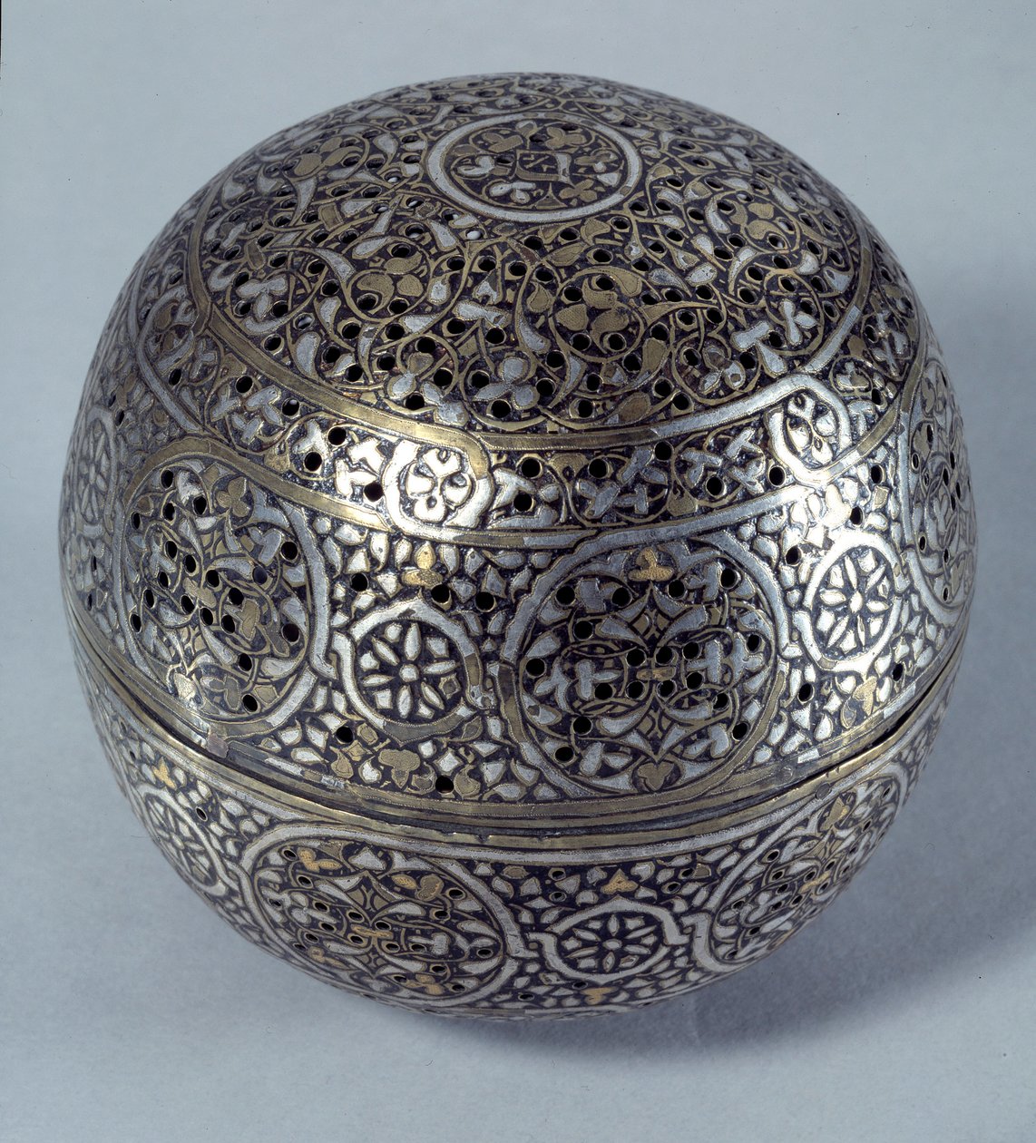 Orientalsk kunst: Frule-parfyme (brenn-parfyme) eller håndvarmer (håndvarmer) fra Syria, slutten av 1400-tallet, begynnelsen av 1500-tallet. Kobberlegering hamret med gravdekor, pierces, innlagt med gull, sølv og sort pasta. Paris, Louvre-museet av Syrian School