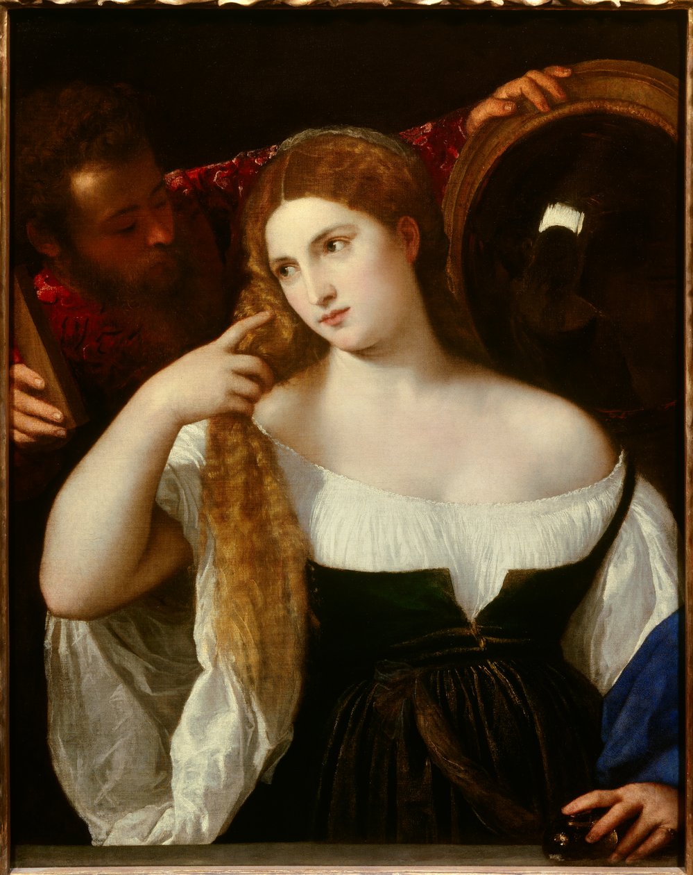 Portrett av en kvinne med toalettet Et speil bak reflekterer scenen. En tjener holder et annet speil for henne, hun ser stille på seg selv. Den unge kvinnen skulle være Laura Dianti, elskerinnen til Alfonso I d