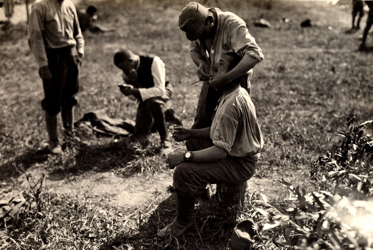 Østerrikske fanger under første verdenskrig i Bagnaria Arsa, Udine, Italia; i forgrunnen barberer en soldat en medsoldat, 02.04.1916 (s/hvitt-bilde) av Ugo Ojetti