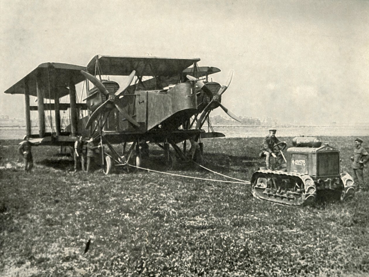 En liten motortraktor som får en enorm R.A.F. Bombingmaskin i posisjon..., 1919. av Unbekannt