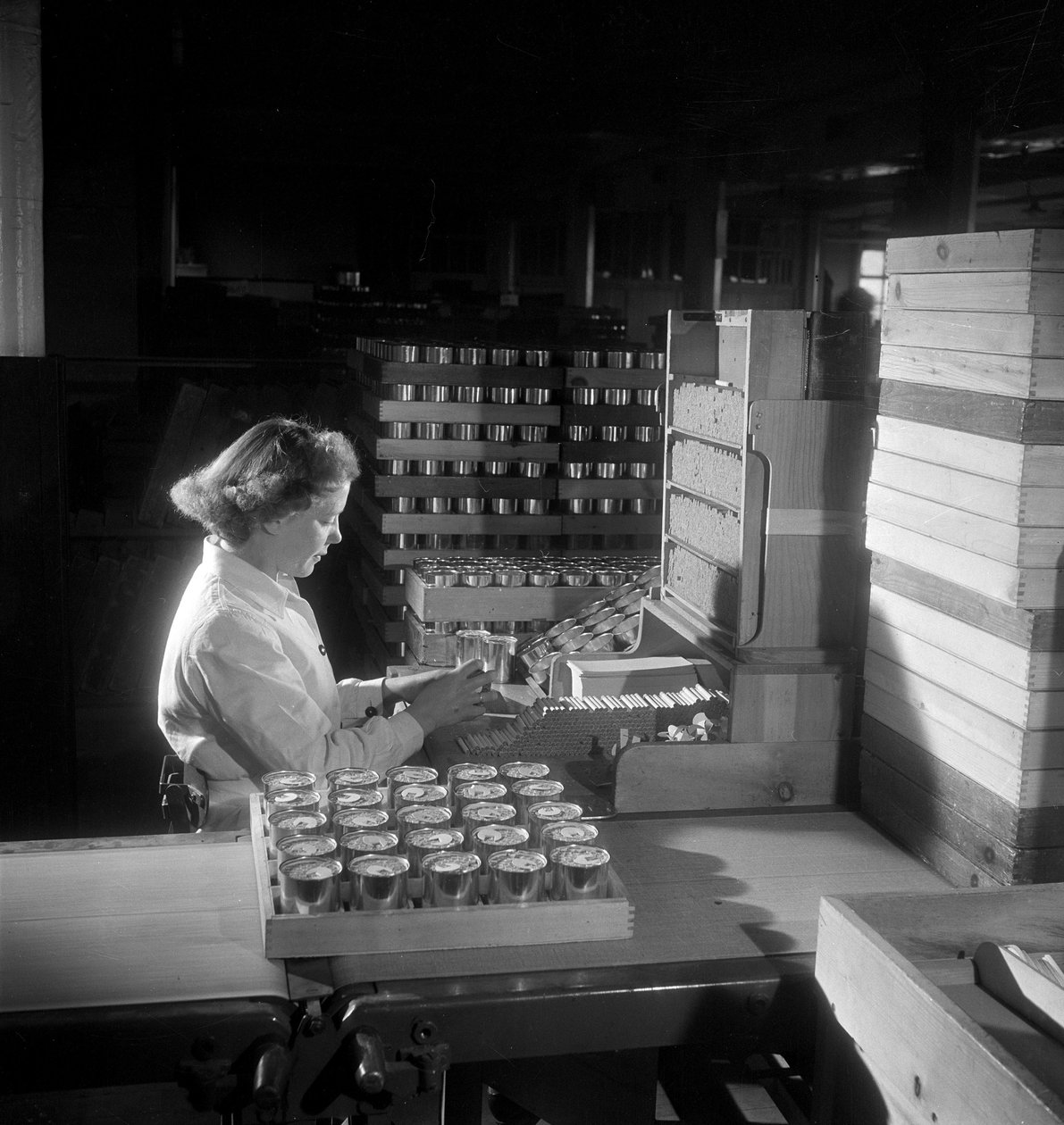 En kvinnelig arbeider pakker bokser med sigaretter, London 1950 av Unbekannt