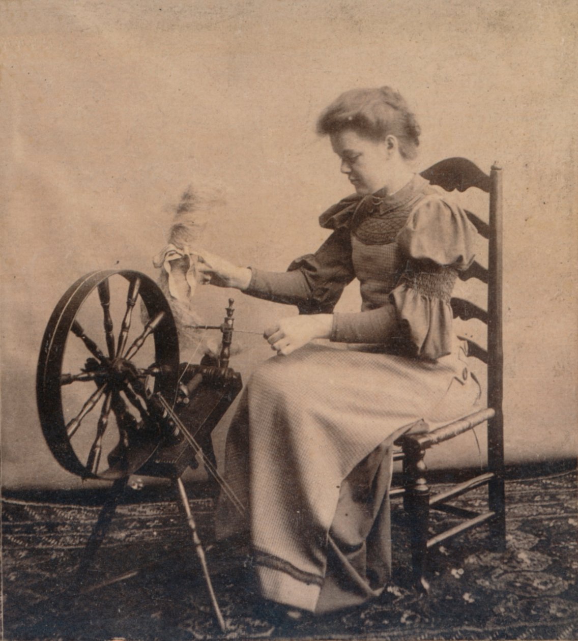 En dame ved et snurrehjul c1900 av Unbekannt