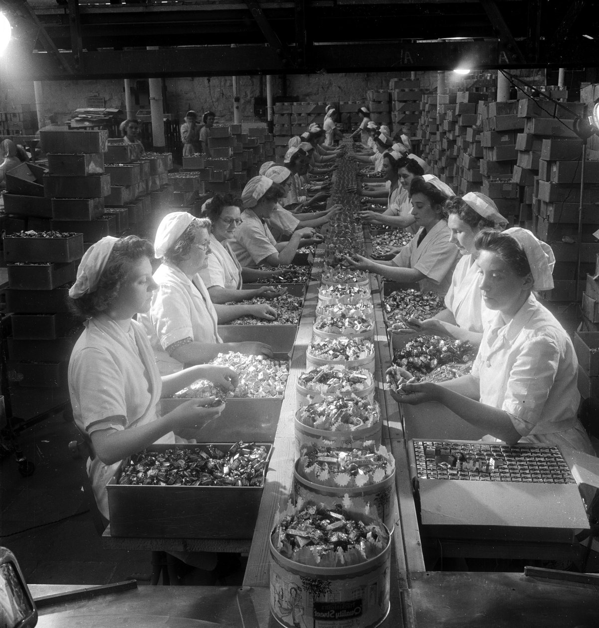 En rekke kvinnelige arbeidere pakker "Quality Street