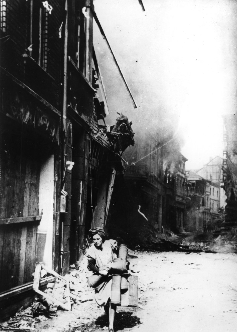En kvinne forlater sitt brennende hus i en bombet gate, Tyskland, 1945 av Unbekannt