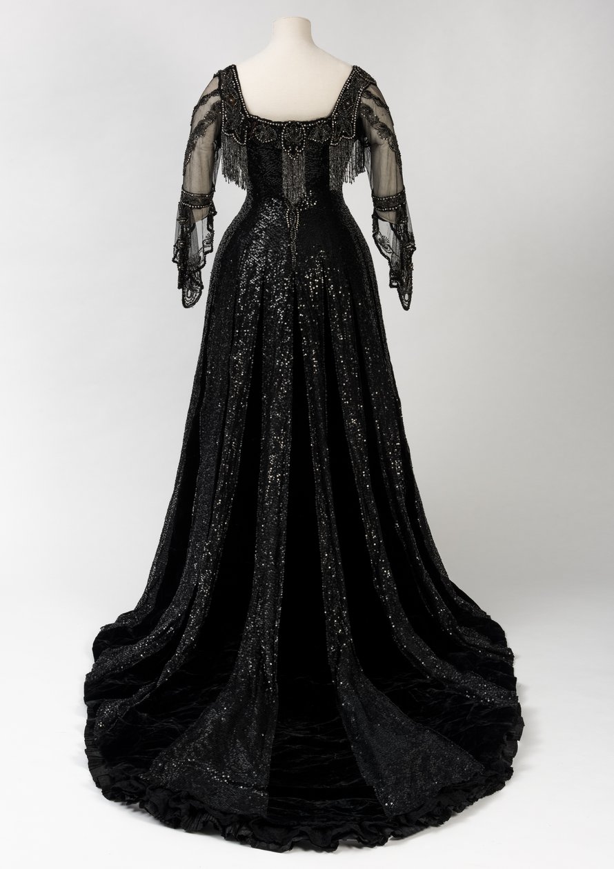 Sort kveldskjole i full lengde båret av dronning Alexandra, med dekorasjon av perler og paljetter og inkorporert dronning Alexandras signaturteip i svart silke og gull, laget av Barolet fra Knightsbridge, London 1908-1910 (silke og fløyel) av Unbekannt