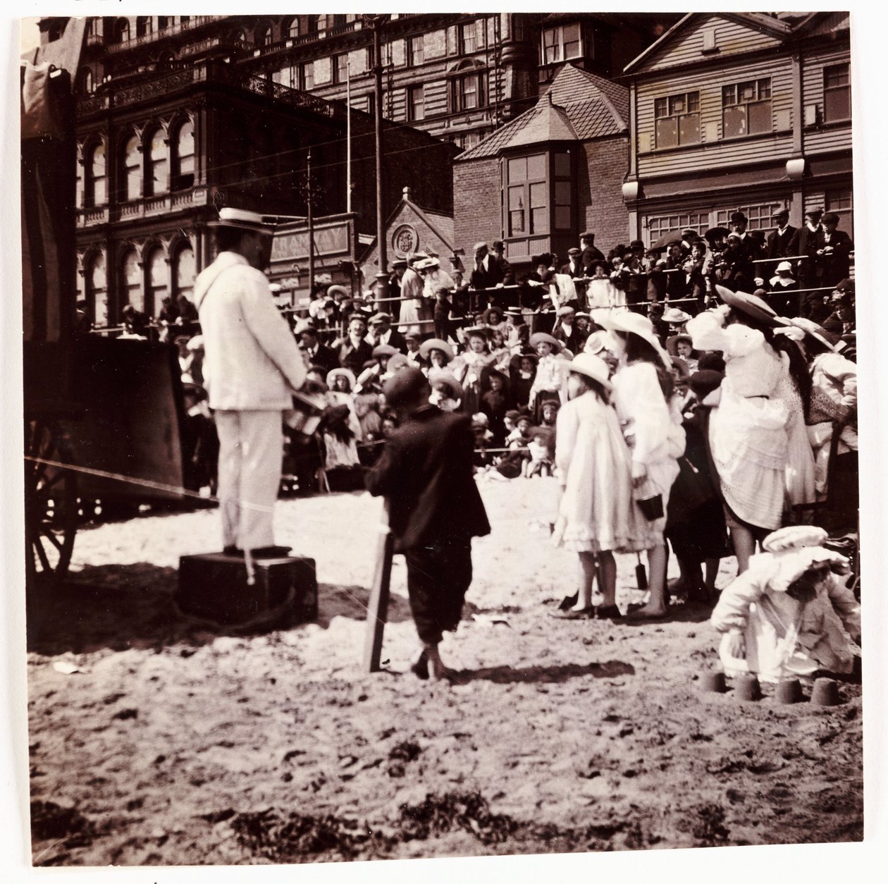 Publikum ser på en strandunderholder, ca 1905 av Unbekannt
