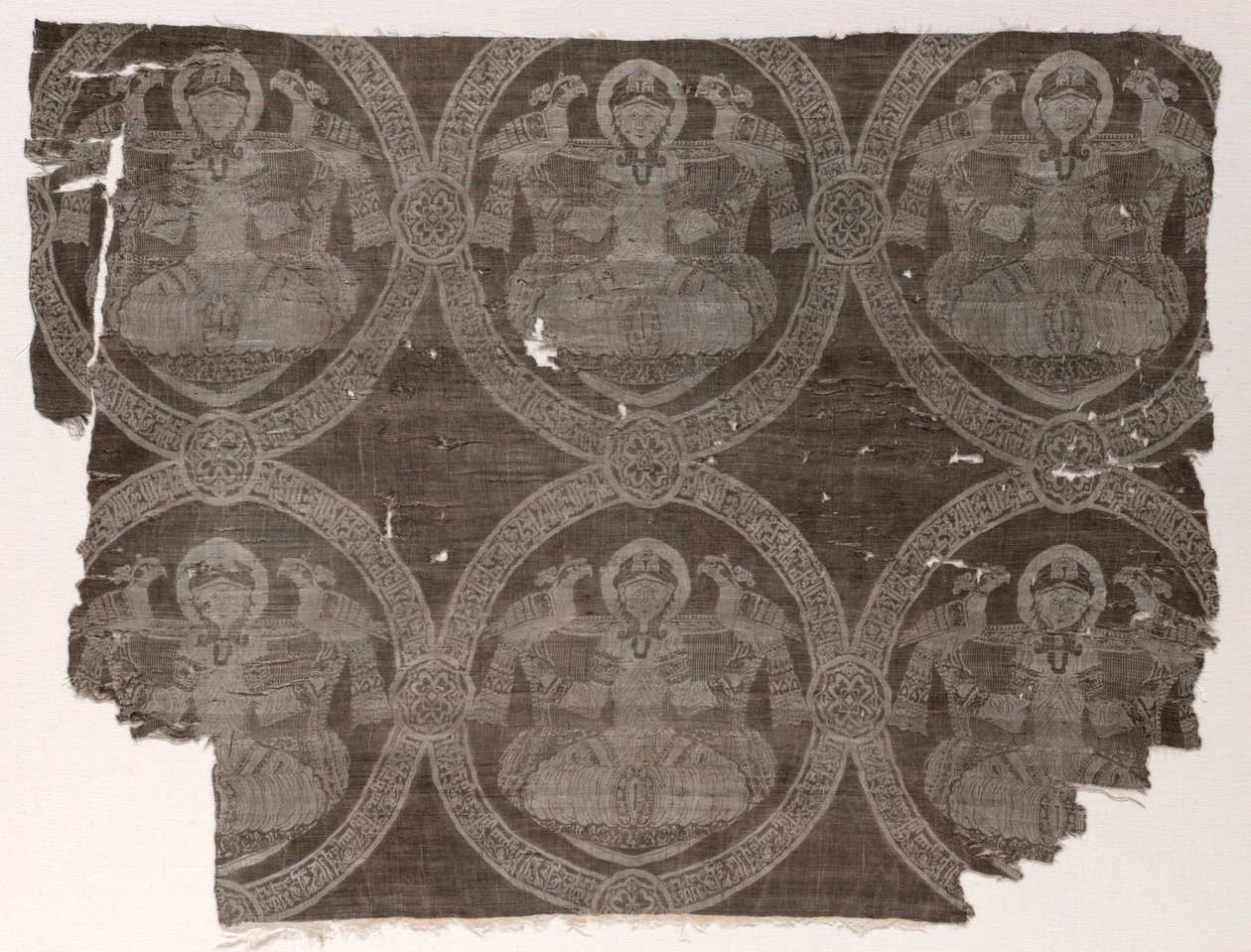 Lampas-fragment med sittende prins som holder falker i kufiske medaljonger, 1654-1955. av Unbekannt
