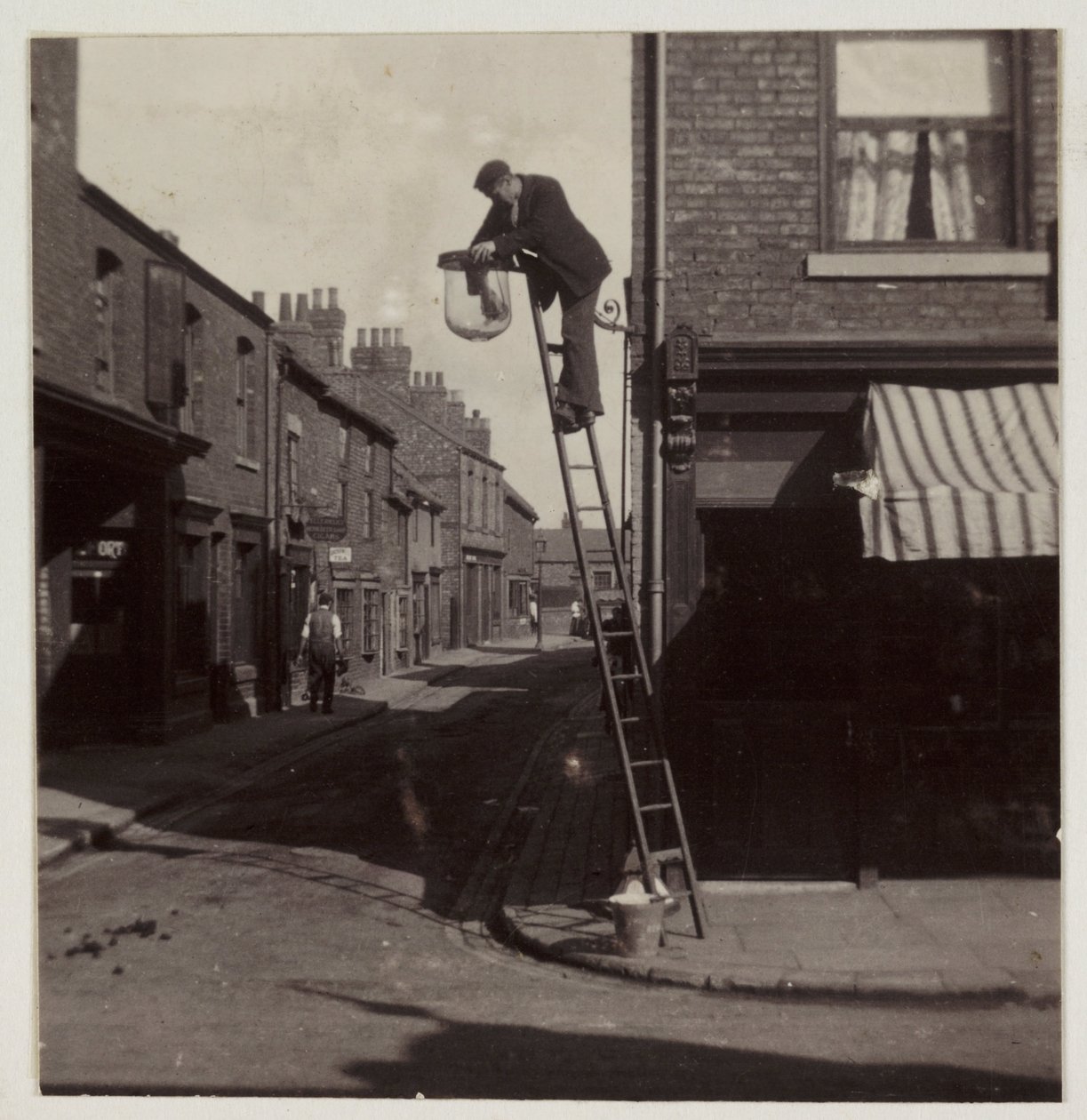 Mann som renser en gassgatelykt, ca 1905 av Unbekannt