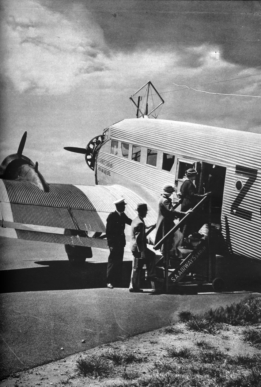 Passasjerer som går ombord på et av Junkers-flyene til South African Airways, c1936 c1937 av Unbekannt