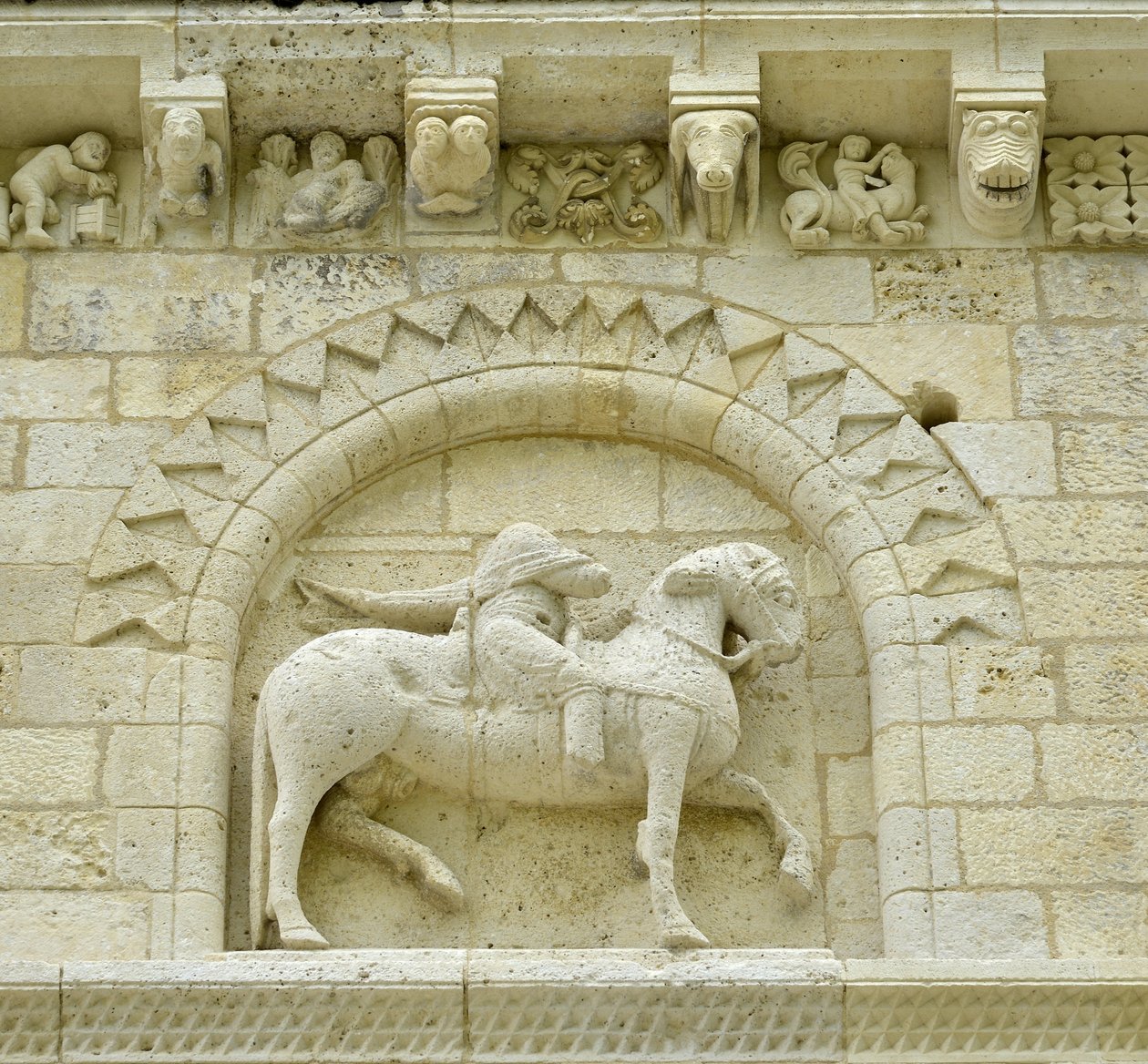 Romansk kunst: detalj av fasaden som viser Hugues de Surgeres og Geoffroy de Vendome eller keiser Konstantin I den store hvis fot av hesten ville tråkke Heresie og Kristus triumferende over ondskap og død, Notre Dame (Notre-Dame) de Surgeres (17700) av Unbekannt