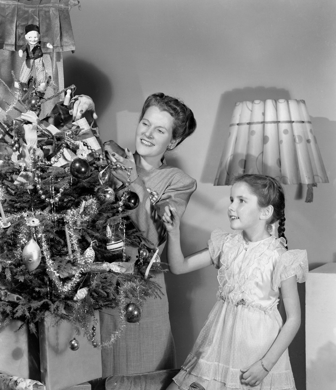 Kvinne og jente pynter et juletre, ca 1948 av Unbekannt