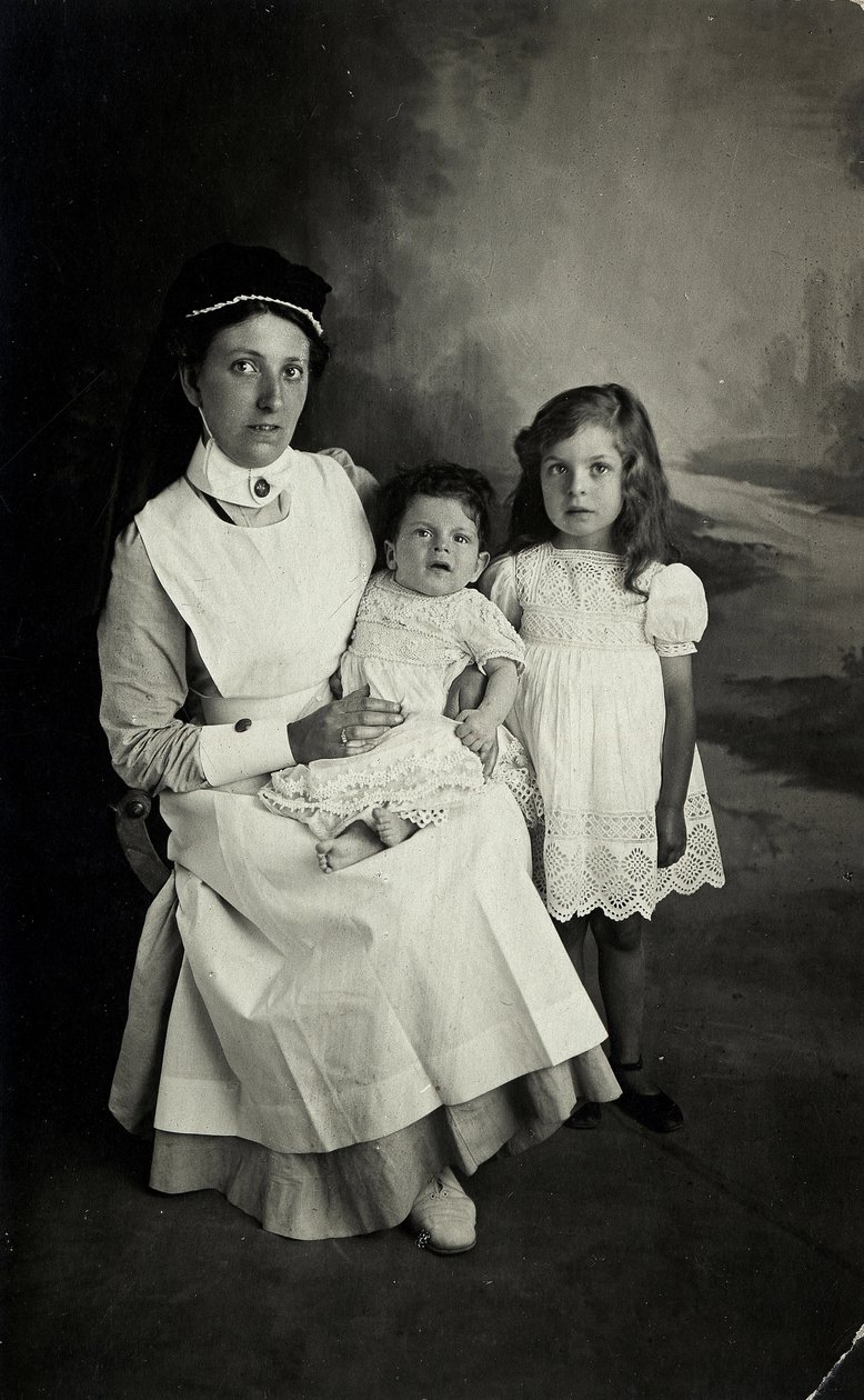 En "sykepleier" som poserer med barn på 1920-tallet. av William M. Timlin