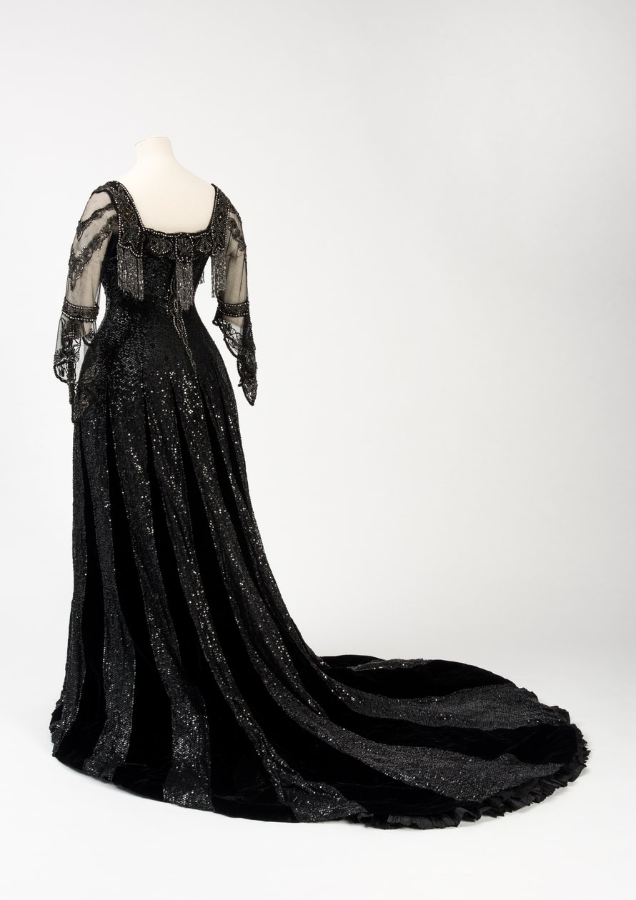 Sort kveldskjole i full lengde båret av dronning Alexandra, med dekorasjon av perler og paljetter og inkorporert dronning Alexandras signaturteip i svart silke og gull, laget av Barolet fra Knightsbridge, London 1908-1910 (silke og fløyel) av Unbekannt