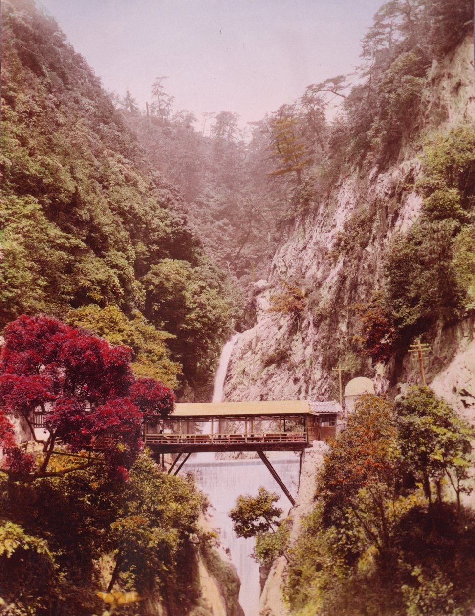 Overbygd bro i en bratt kløft, med fossefall i bakgrunnen, Japan, ca. 1890-1910 av Unbekannt