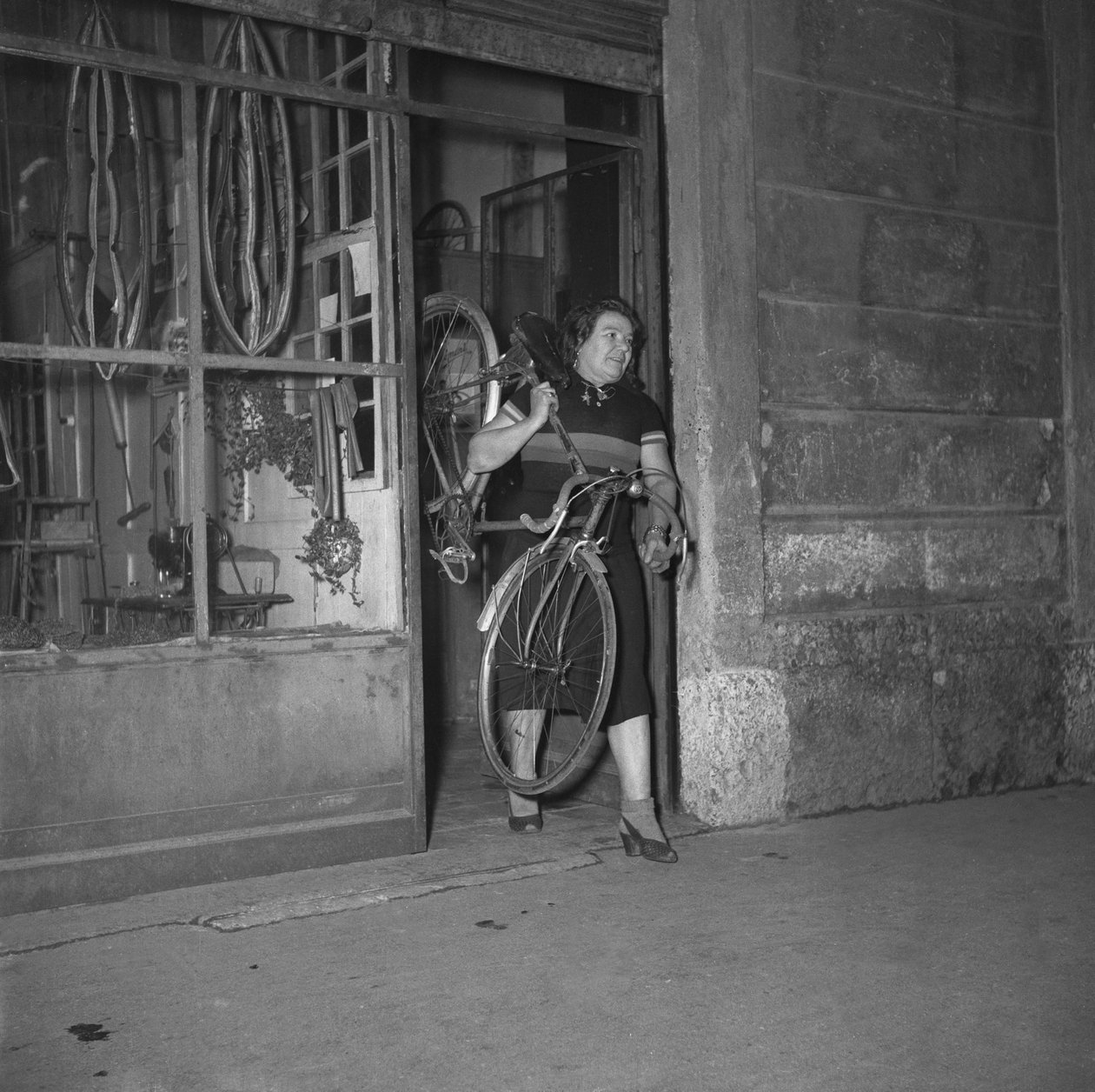 Syklisten Alfonsina Strada (Alfonsa Rosa Maria Morini) går ut av butikken sin i Varesina-gaten 80, Milano, Italia av Unbekannter Künstler