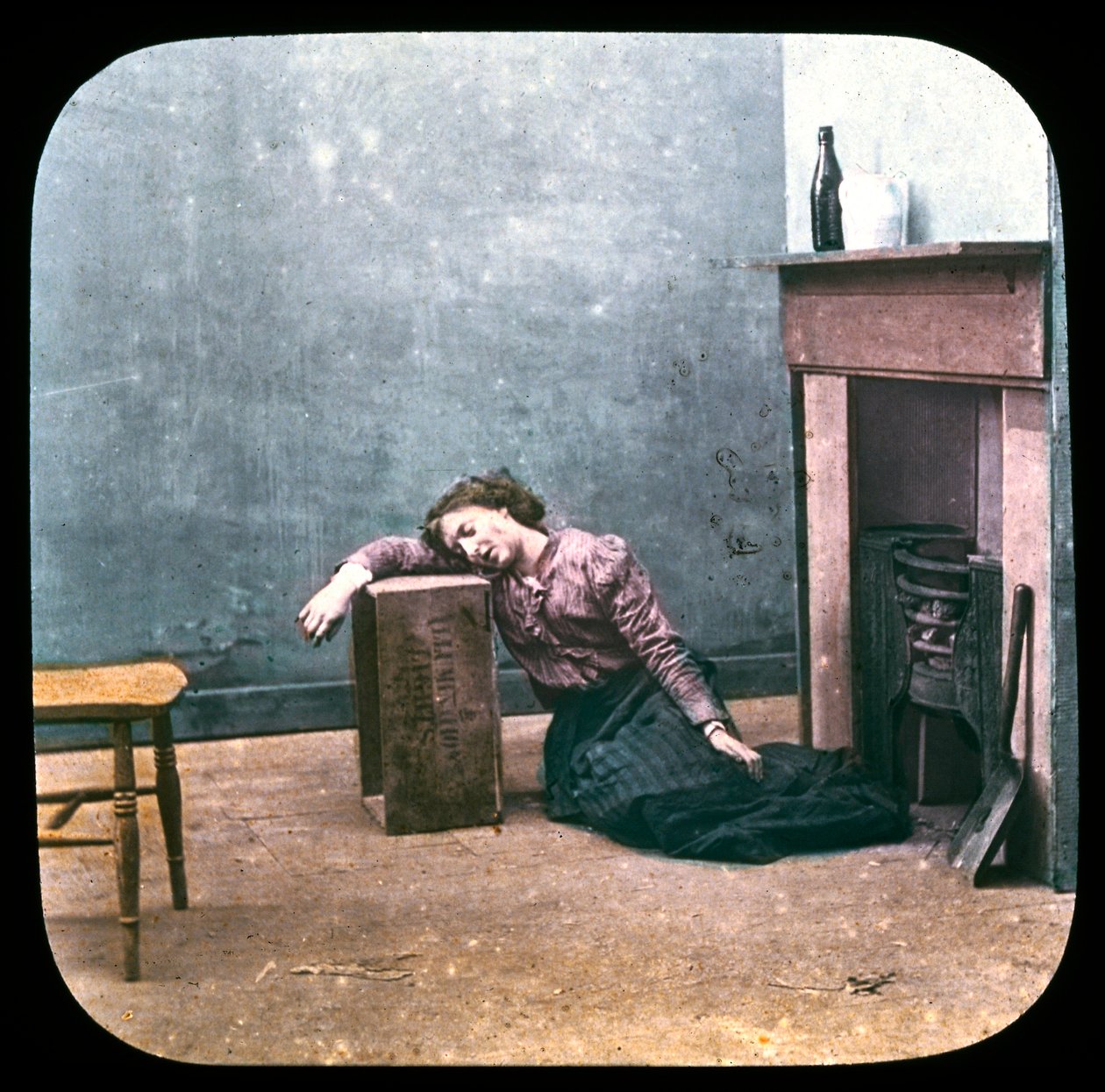 Beruset kvinne på gulvet foran peisen, ca 1895 av Unbekannt