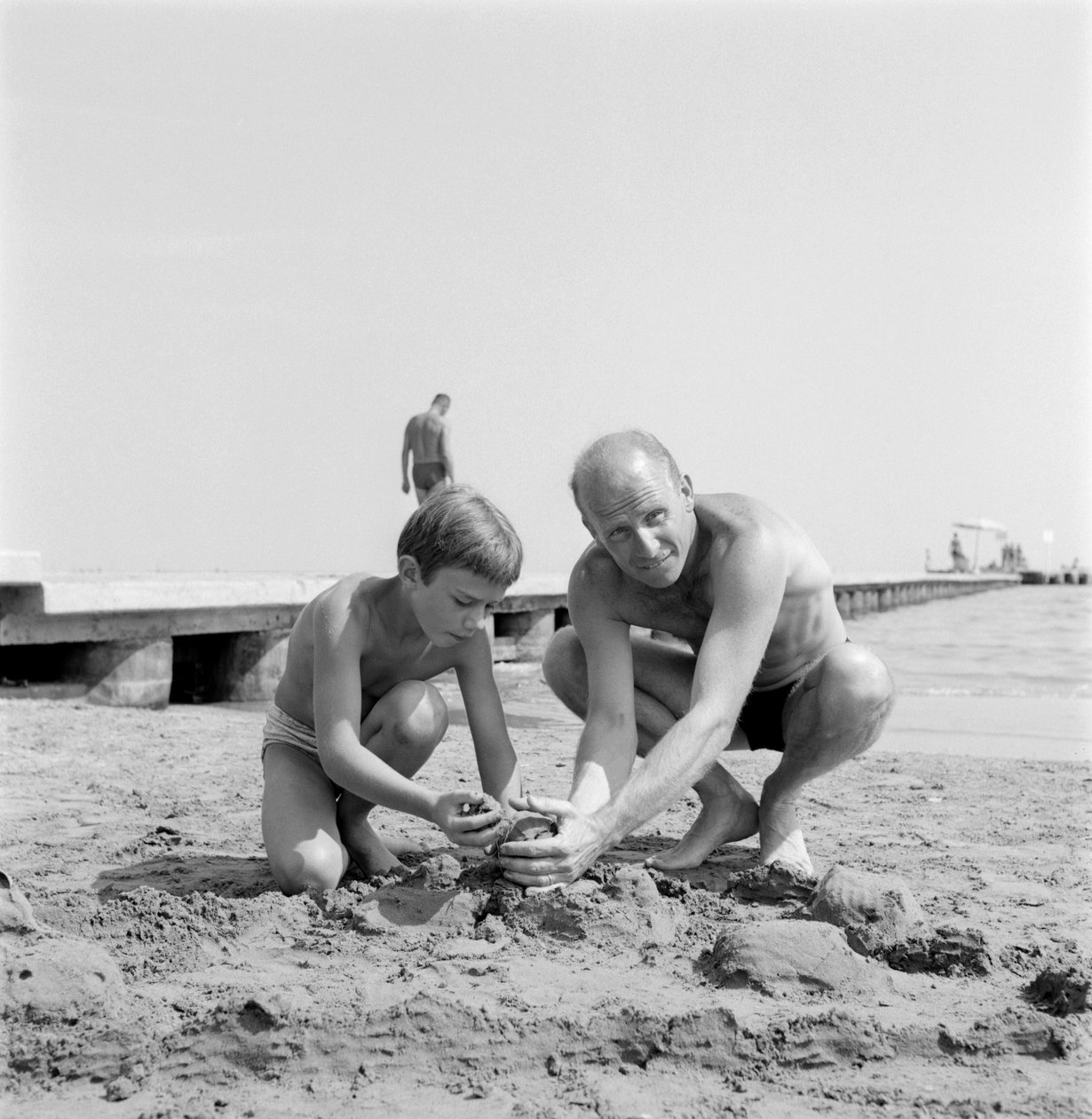 REGISSØREN ALBERT LAMORISSE MED SØNNEN SKUESPILLEREN PASCAL LAMORISSE PÅ VENICE LIDO-STRAND - 1960 av Unbekannt