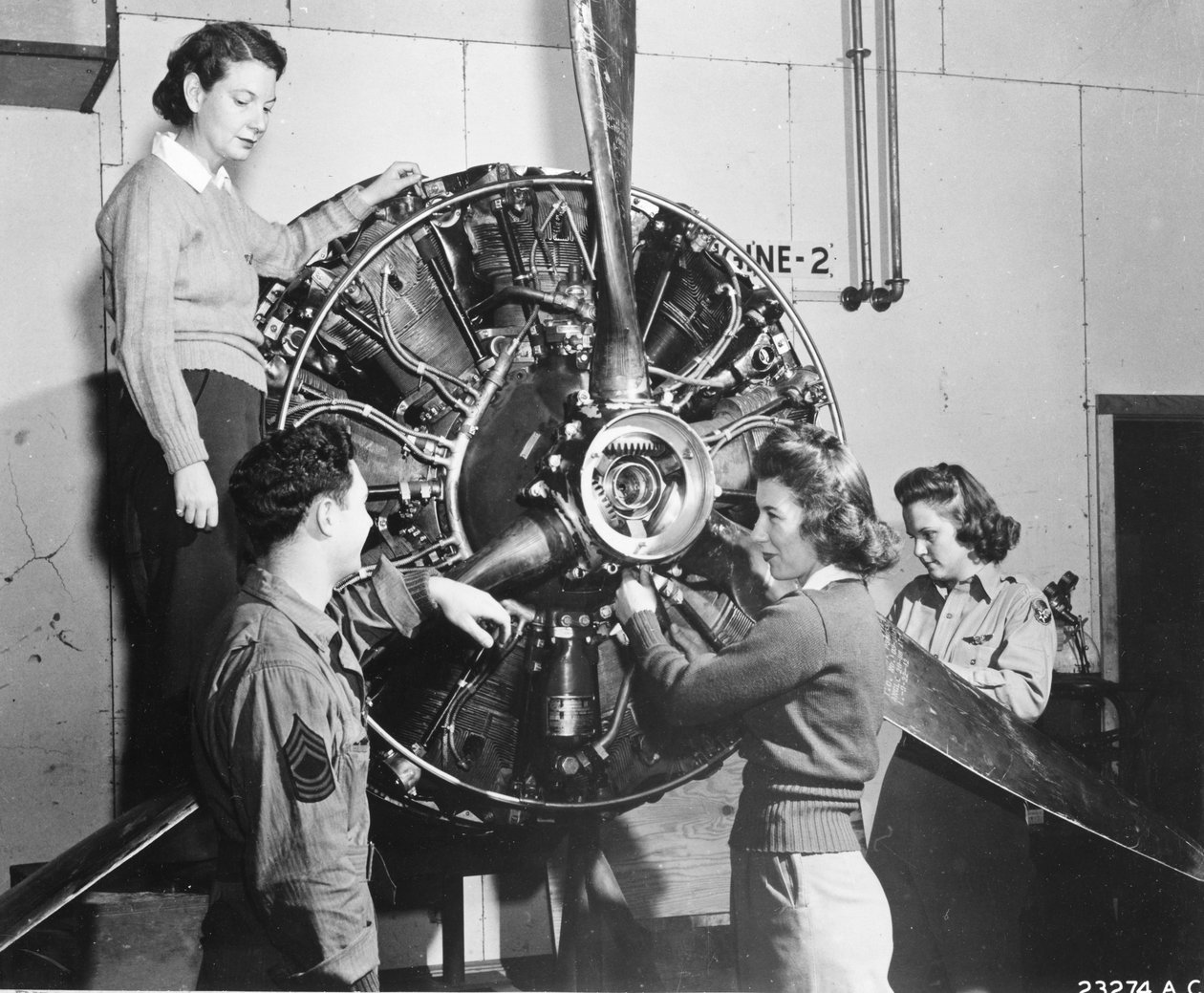 Vepsene lærer hvor kraften kommer fra i B-17 Flying Fortress-motoren mens de går på B-17 pilotopplæring ved Lockbourne AAB, jobber med propellmekanismen, mens en besetningssjef ser på, er de (lr): Patricia Bowser, Ann Waldner og Frances Green av Benjamin Baud