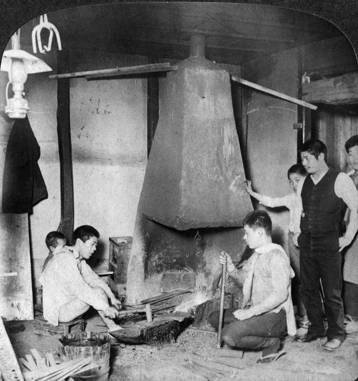 En japansk smed i smia hans, Yokohama, Japan, 1904. av Underwood and Underwood