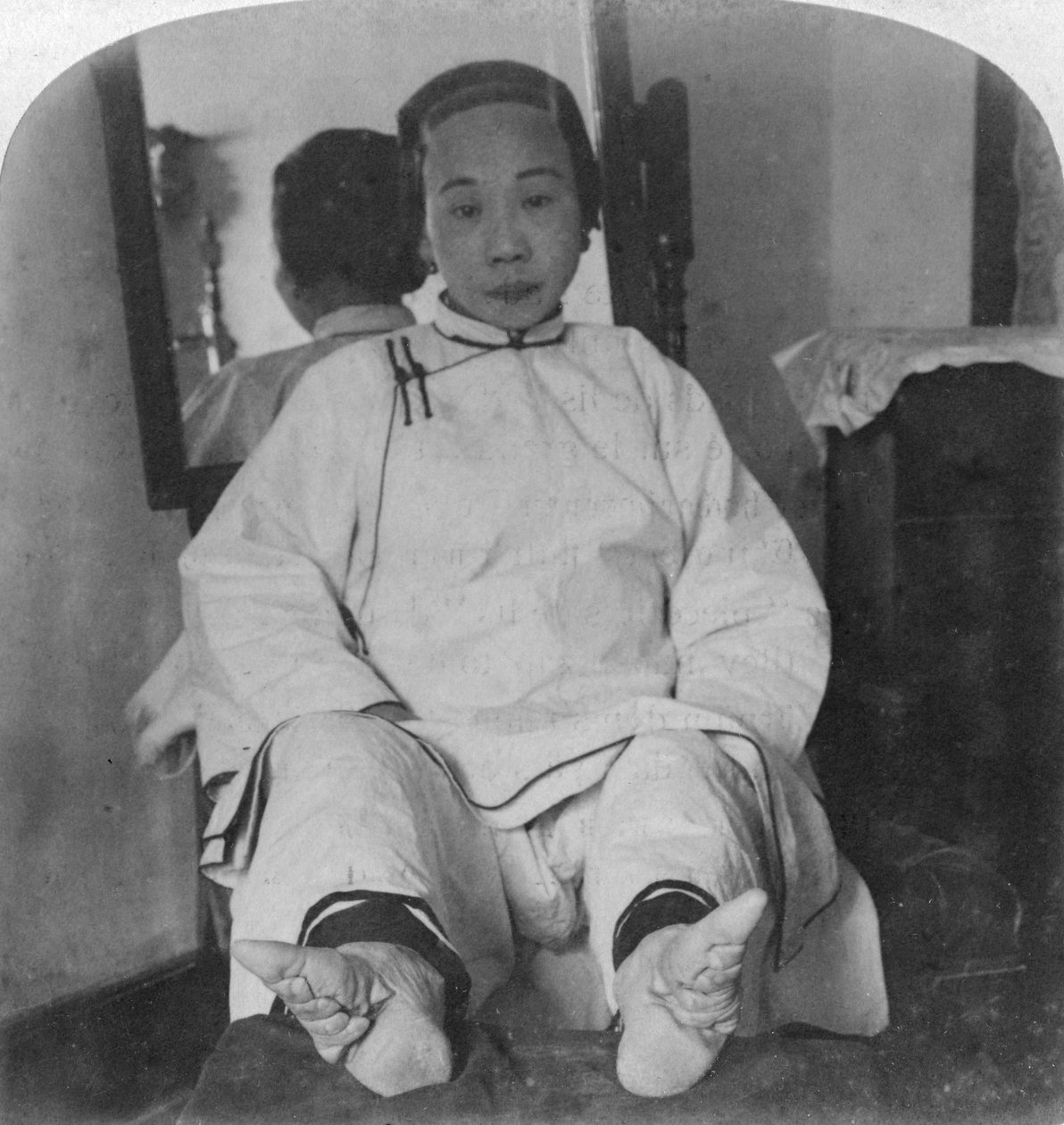En høy kastedame har lekre liljeføtter, som viser misdannelsesmetode, Kina, 1900. av Underwood and Underwood