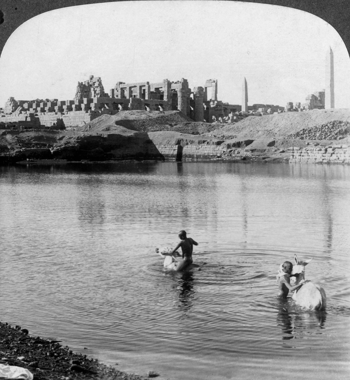 Ser over den hellige innsjøen til det store tempelet i Karnak, Theben, Egypt, 1905. av Underwood and Underwood