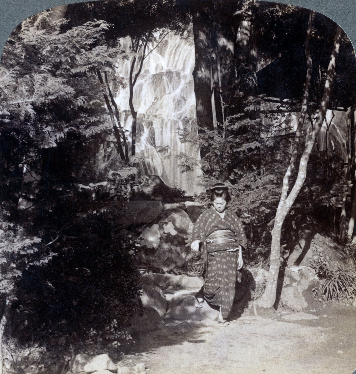 Sprutende vann fra en foss ved Yumoto, Japan, 1904. av Underwood and Underwood
