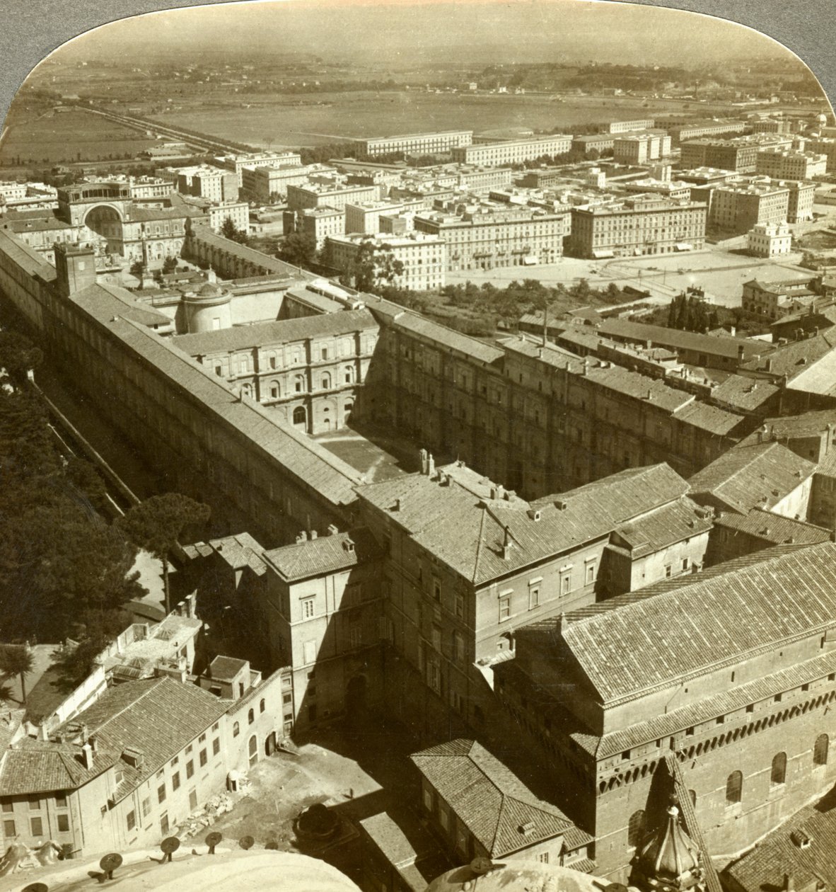 Vatikanpalasset fra kuppelen til Peterskirken, Roma, Italia. av Underwood and Underwood