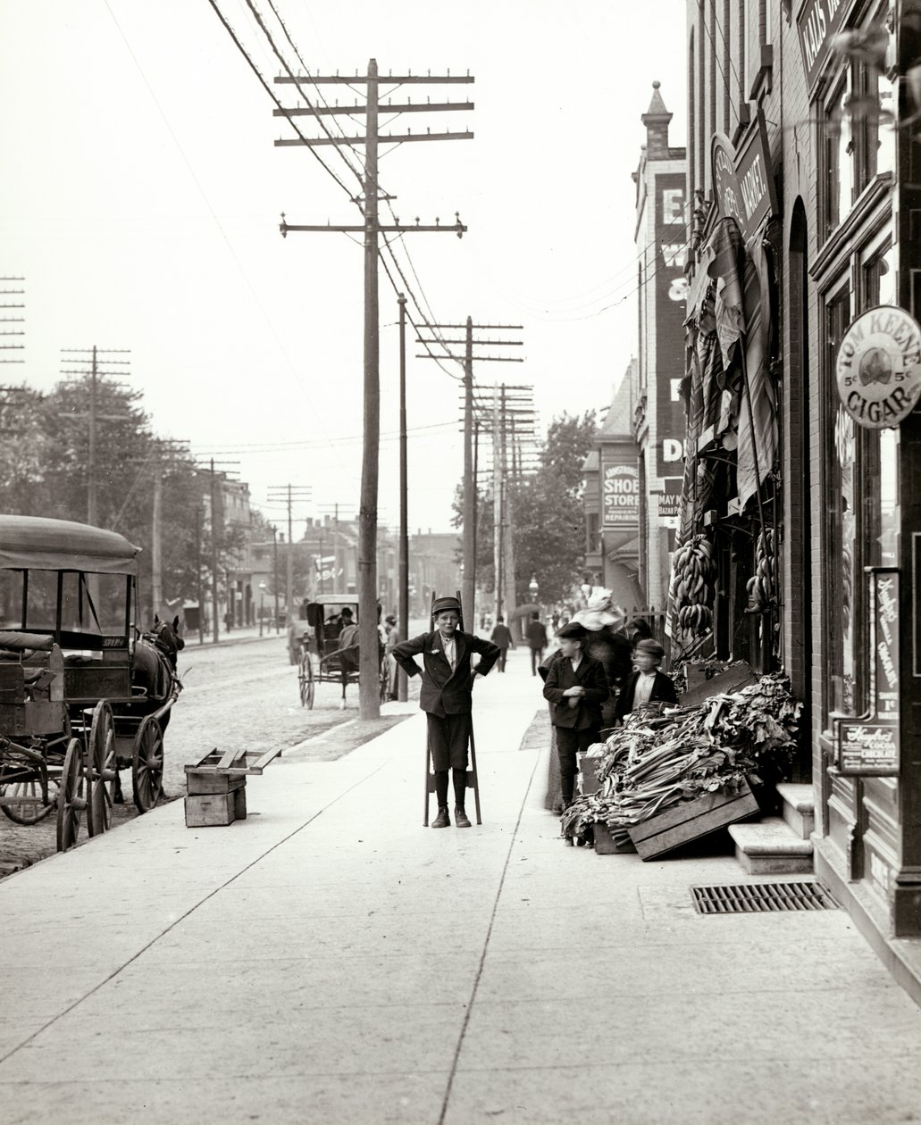 En gutt med stylter som sto foran F.J. Voepel Market på 4874 Easton Avenue, i det sørøstlige hjørnet av Easton og Euclid. Easton ble senere kjent som Dr. Martin Luther King Drive av Unknown