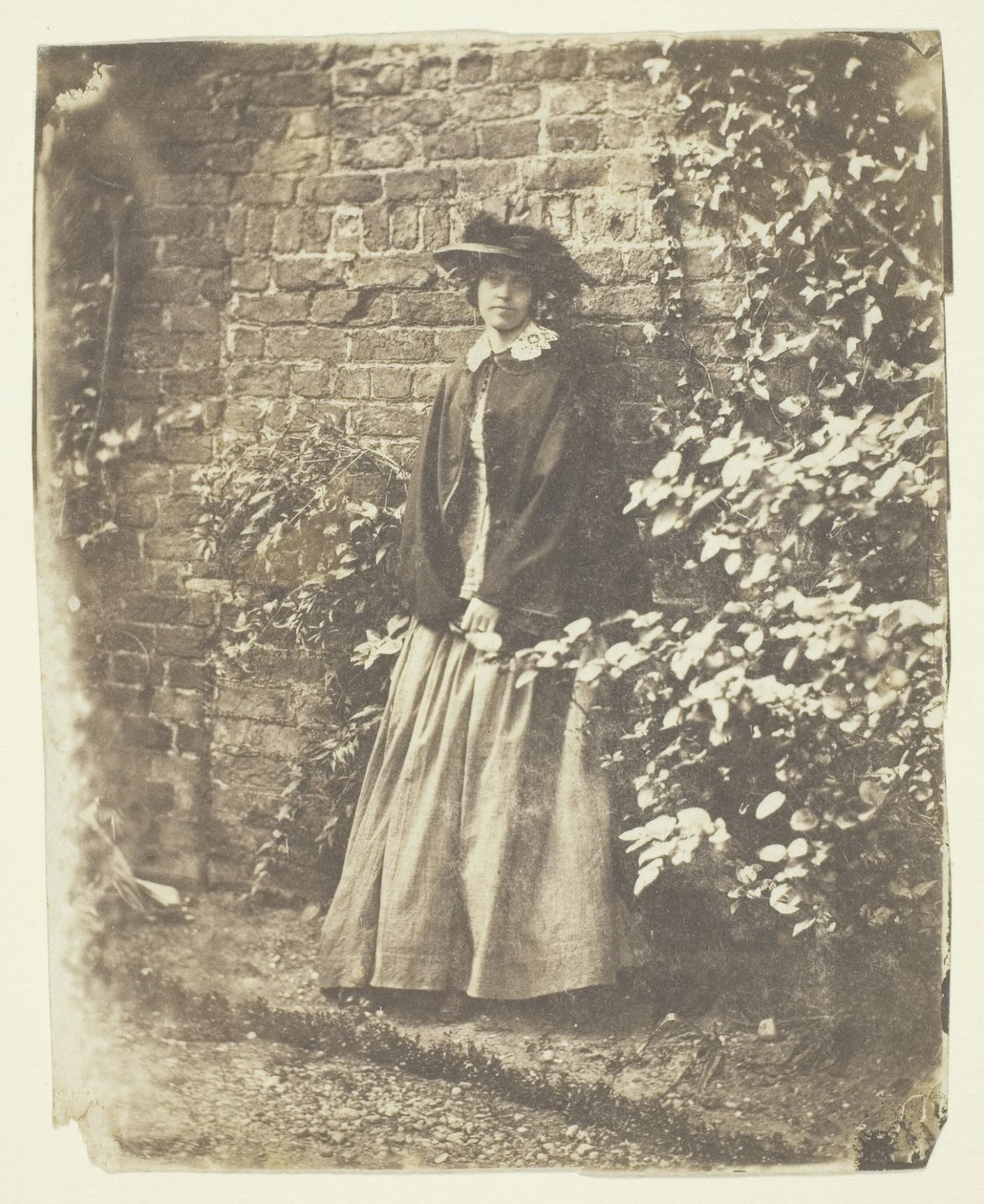 Mrs. Craik lener seg mot vegg og busker av Unknown