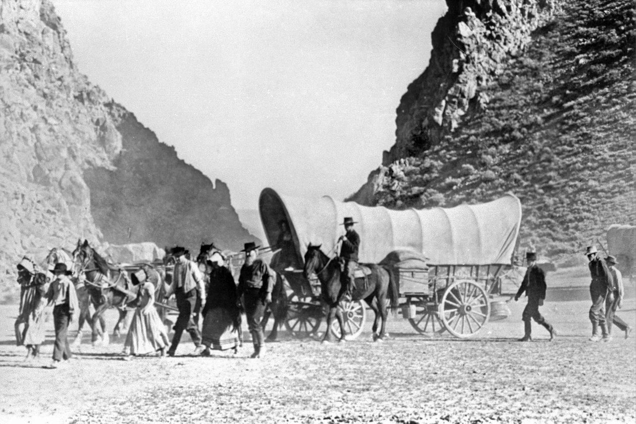 Dekket vogn og nybyggere som krysser Vesten ca. 1850 av Unknown artist