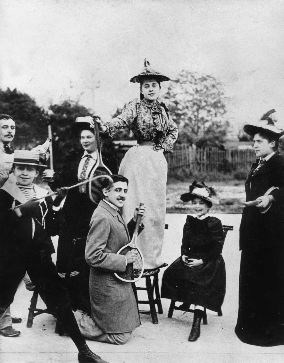 Marcel Proust (1871-1922) knelende med en tennisracket foran Jeanne Ponquet stående på en stol i Neuilly (Frankrike) 1892 av Unknown photographer