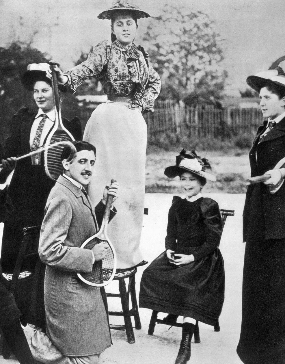 Marcel Proust, midt i en gruppe unge kvinner, spiller gitar på en tennisracket på Bineau Boulevard i Paris av Unknown photographer