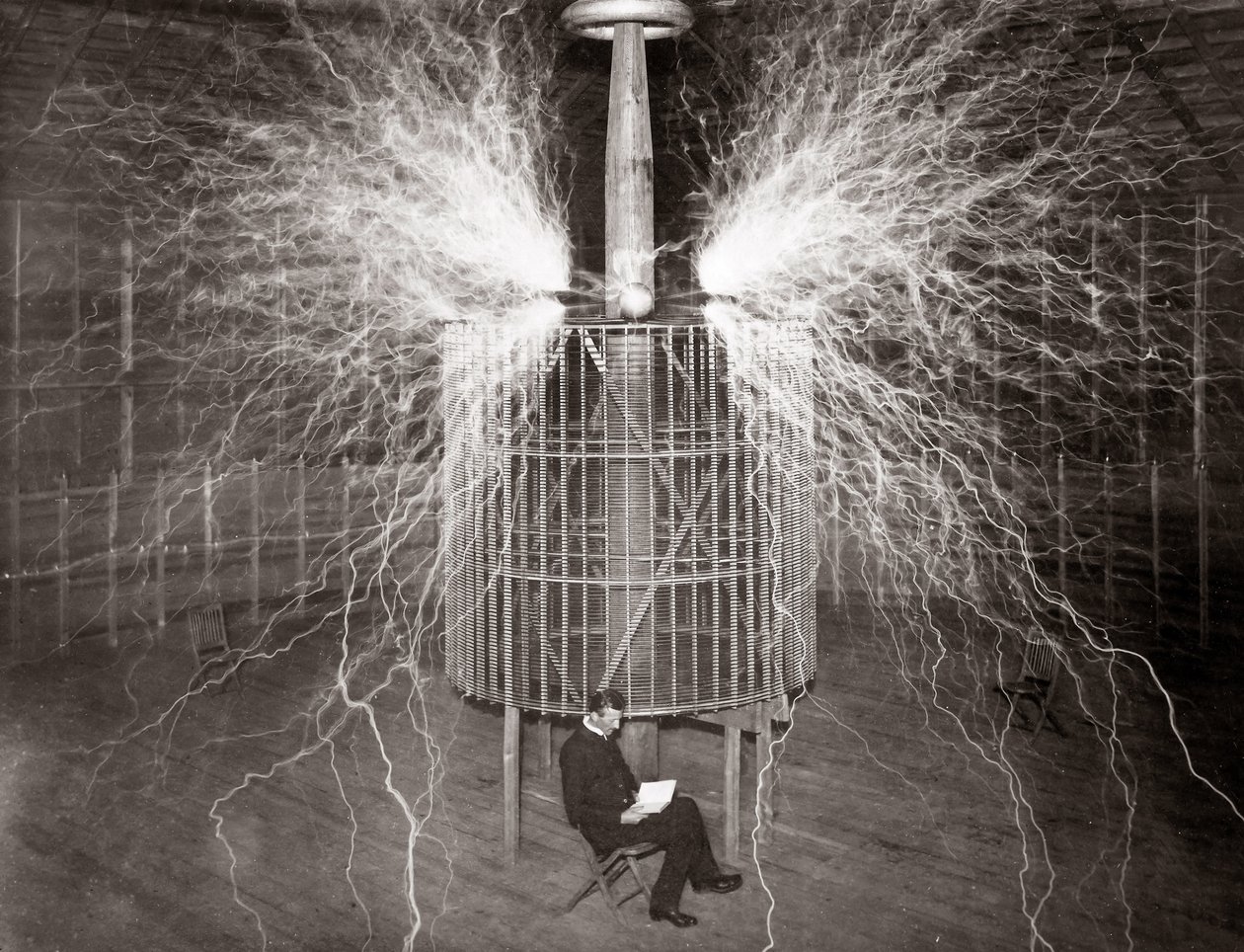 Nikola Tesla sitting in his Colorado Springs laboratory with his “Magnifying Transmitter” av Unknown photographer