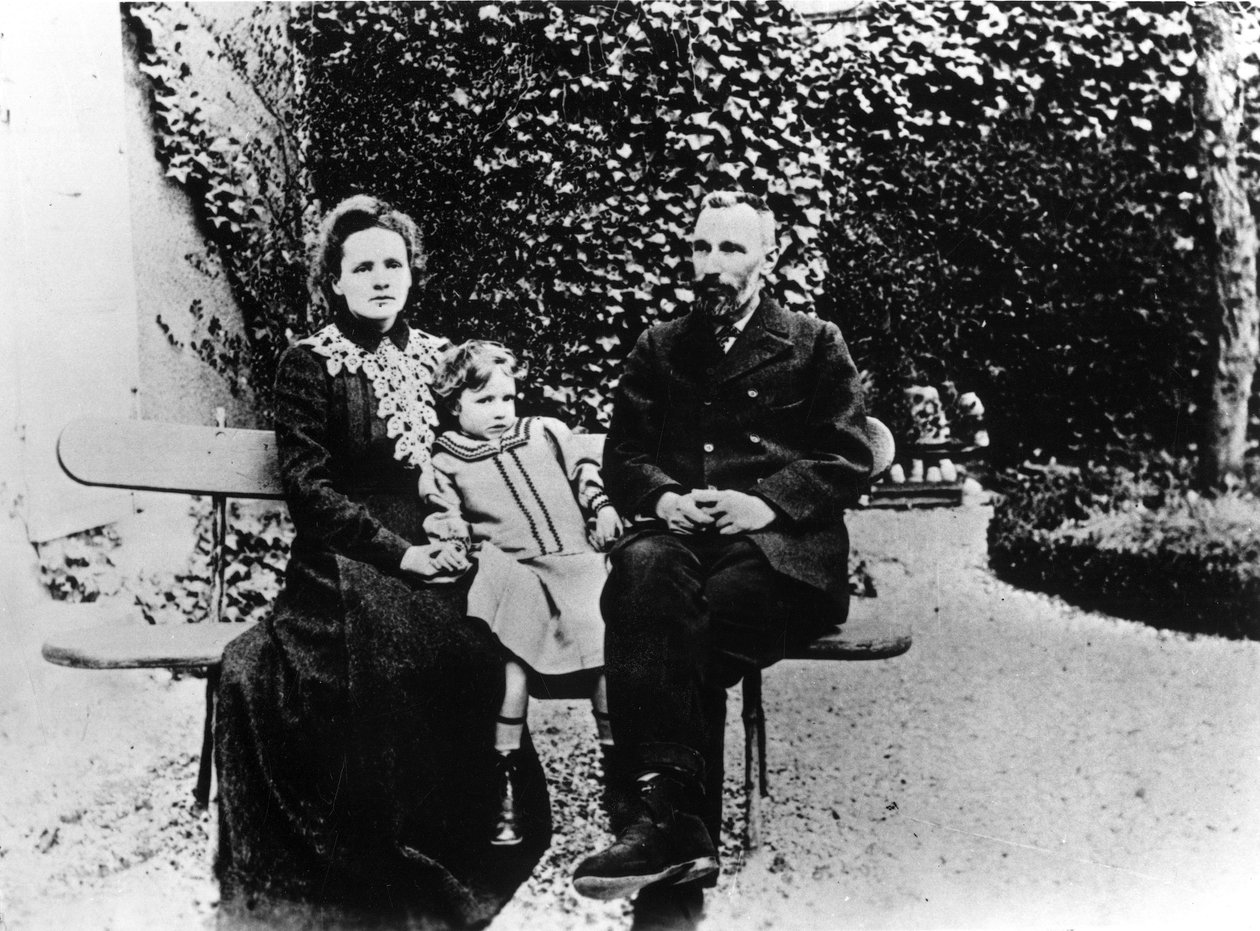 Pierre (1859-1906) og Marie Curie (1867-1934) sitter på en benk i en hage. av Unknown photographer