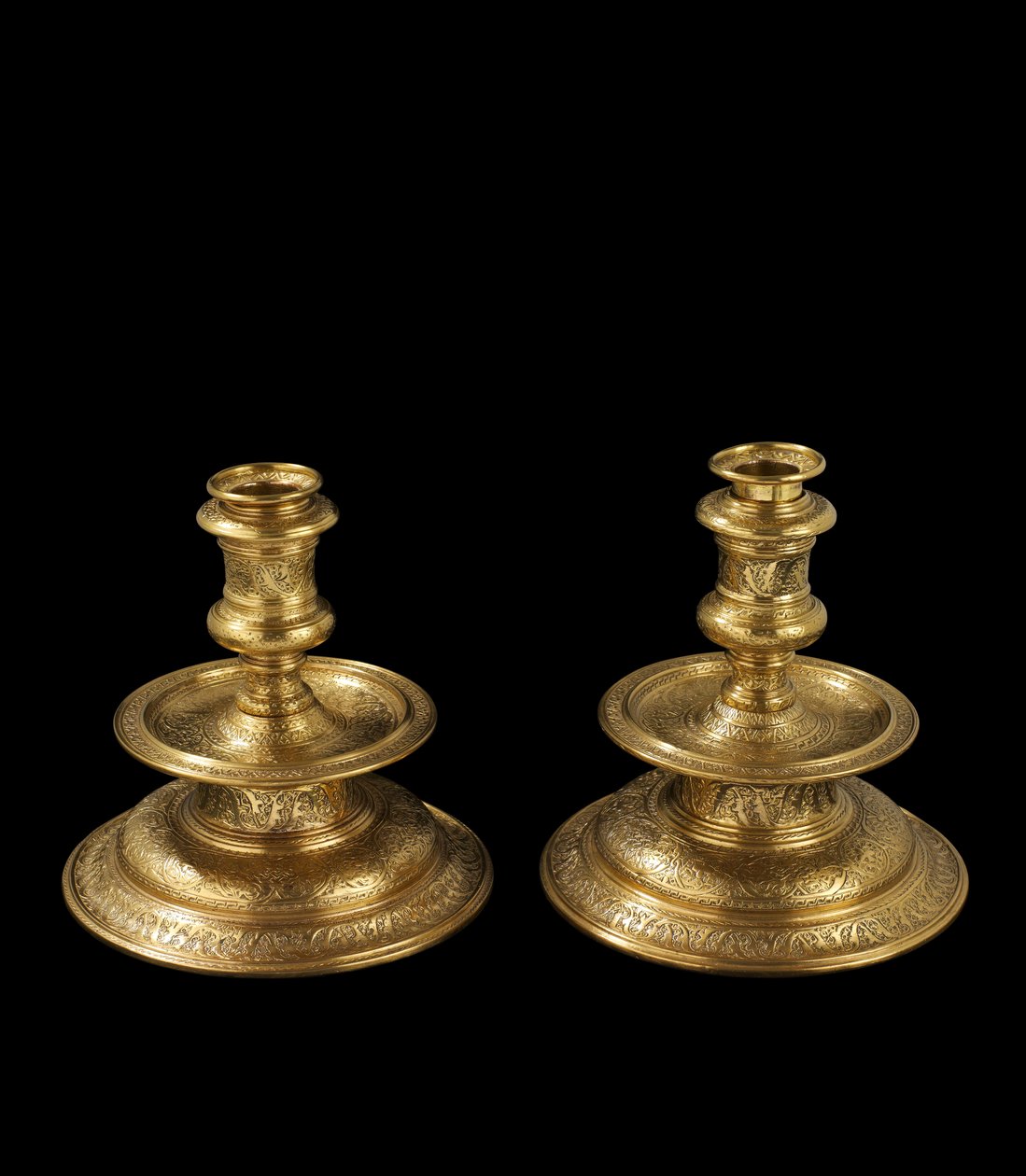 Et par lysestaker av gravert messing, med senere omarbeiding, forgylling og tillegg av avtakbare fatninger og trebunner, 1500-25 av Venetian School