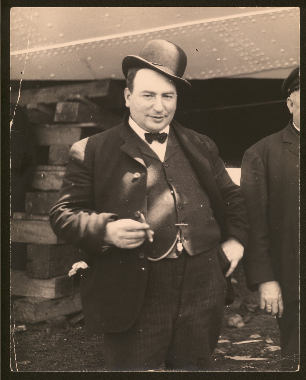 Vertikalt, svart -hvitt fotografi av en mann i derbyhatt og sløyfe som røyker en sigar av William G. Swekosky