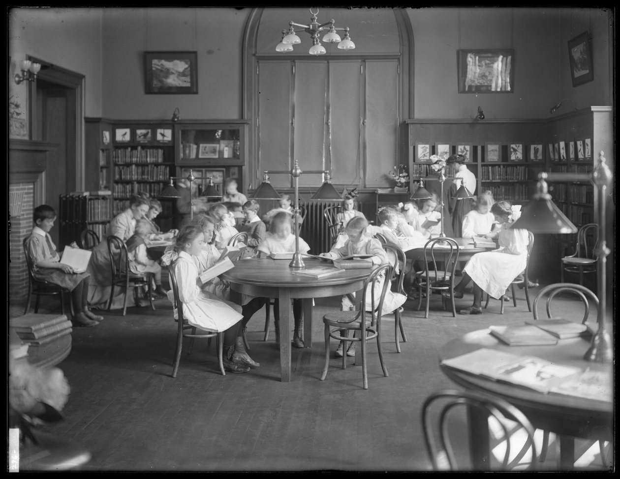 Barn som leser på lesesalen til en uidentifisert filial av Queens Borough Public Library, ca. 1910 av William Davis Hassler