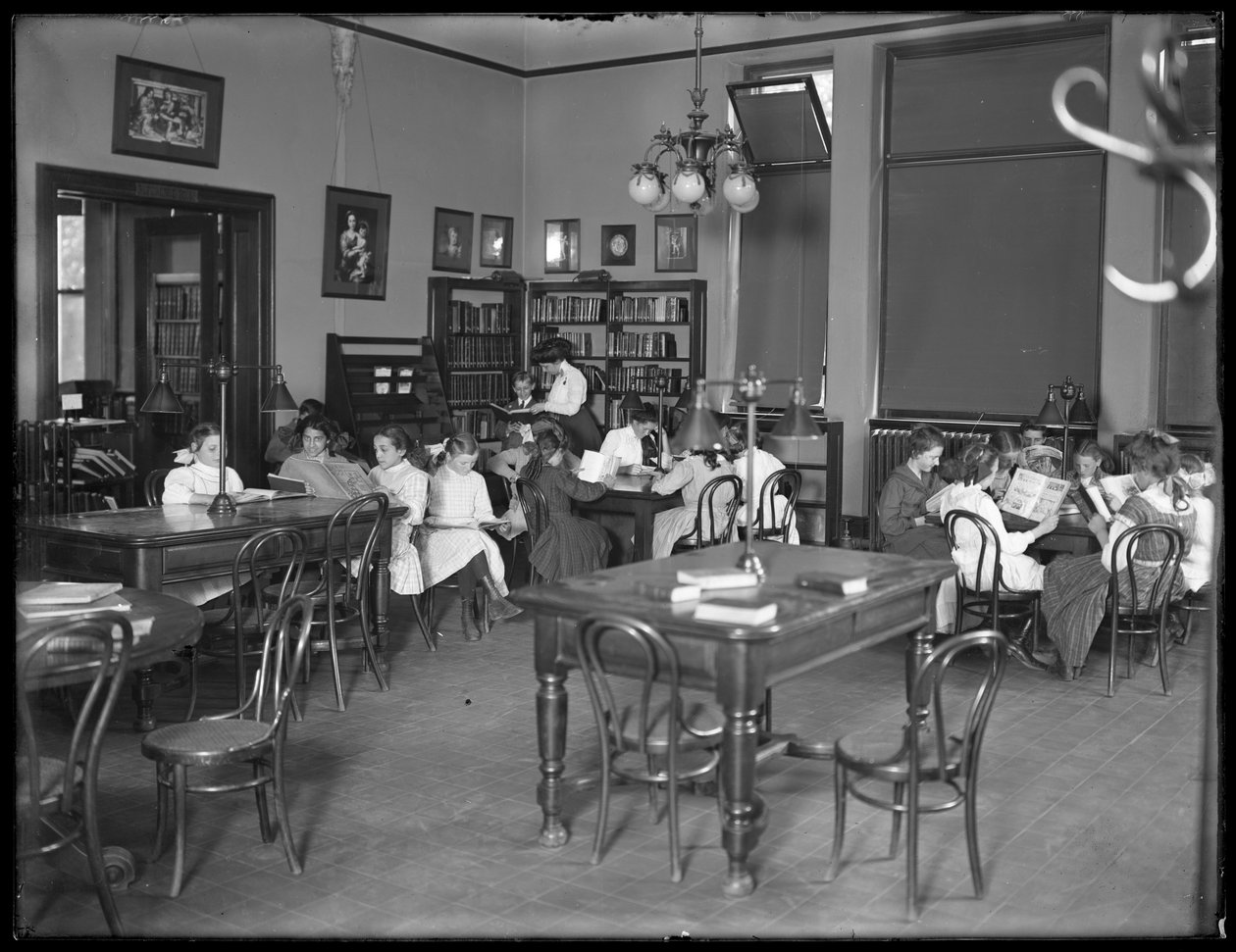Barn som leser på lesesalen til en uidentifisert filial av Queens Borough Public Library, ca. 1910 av William Davis Hassler