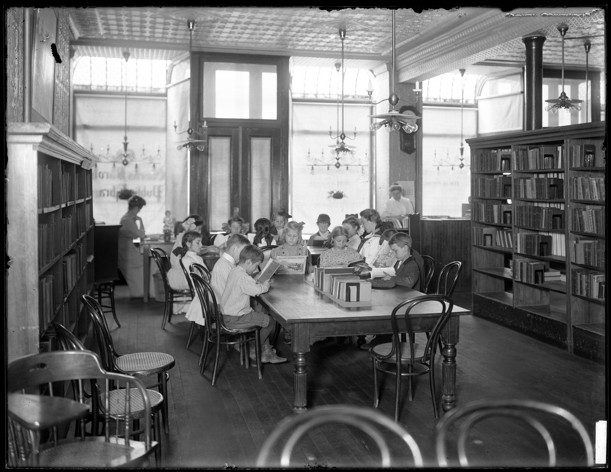 Barn som leser på lesesalen til en uidentifisert filial av Queens Borough Public Library, ca. 1910 av William Davis Hassler