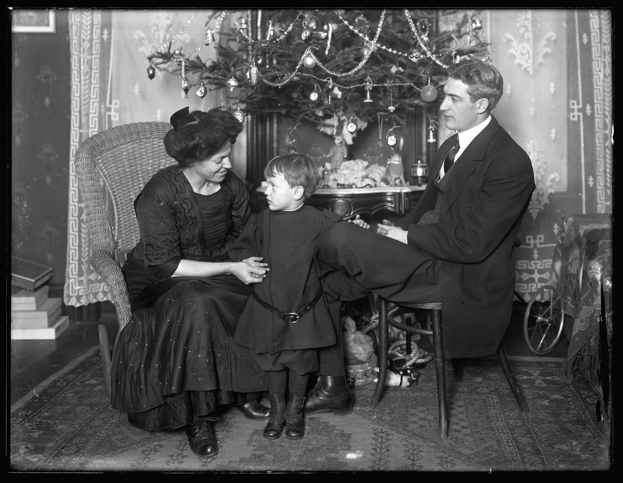 Dan Seymour og familie i uformell positur, sittende under et juletre, julen 1912 av William Davis Hassler