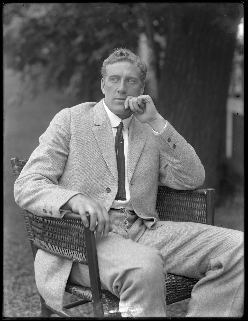 Den engelske bokseren William Thomas Wells (Bombardier Billy Wells), poserte sittende i en tweed-drakt, ca. 1911 av William Davis Hassler