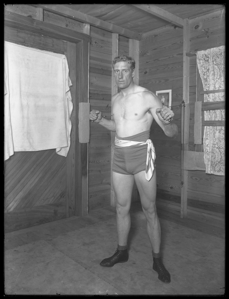 Den engelske bokseren William Thomas Wells (Bombardier Billy Wells), poserer i treningsbukser med vektskiver, ca. 1911 av William Davis Hassler