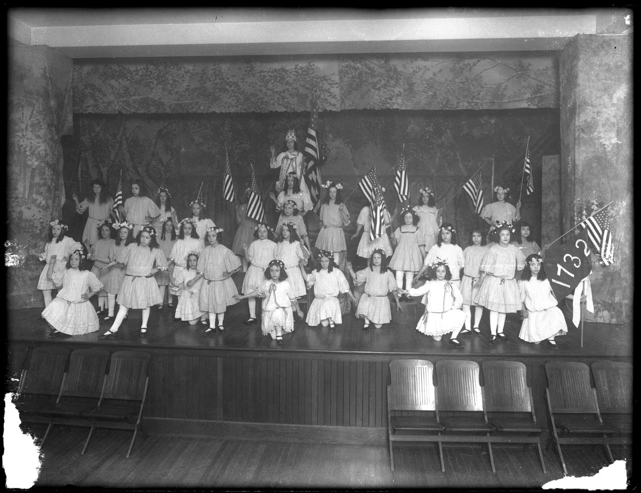 Gruppeportrett av små jenter under en forestilling, sannsynligvis det romersk-katolske orphan asylum, Kingsbridge, Bronx, ca. 1911 av William Davis Hassler