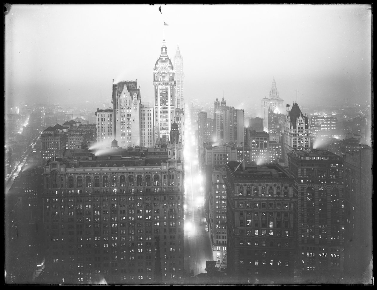 Høyvinklet tåkete nattutsikt over nedre Manhattan ser nordover, med Singer Building, Woolworth Building og Municipal Building synlig, ca. 1913 av William Davis Hassler