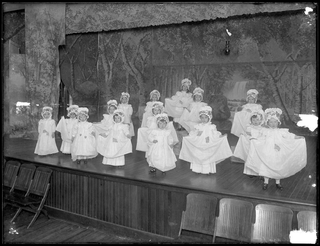 Barnehagebarn på scenen: veldig små jenter opptrer på en liten scene, sannsynligvis det romersk-katolske orphan asylum, Kingsbridge, Bronx, ca. 1911 av William Davis Hassler