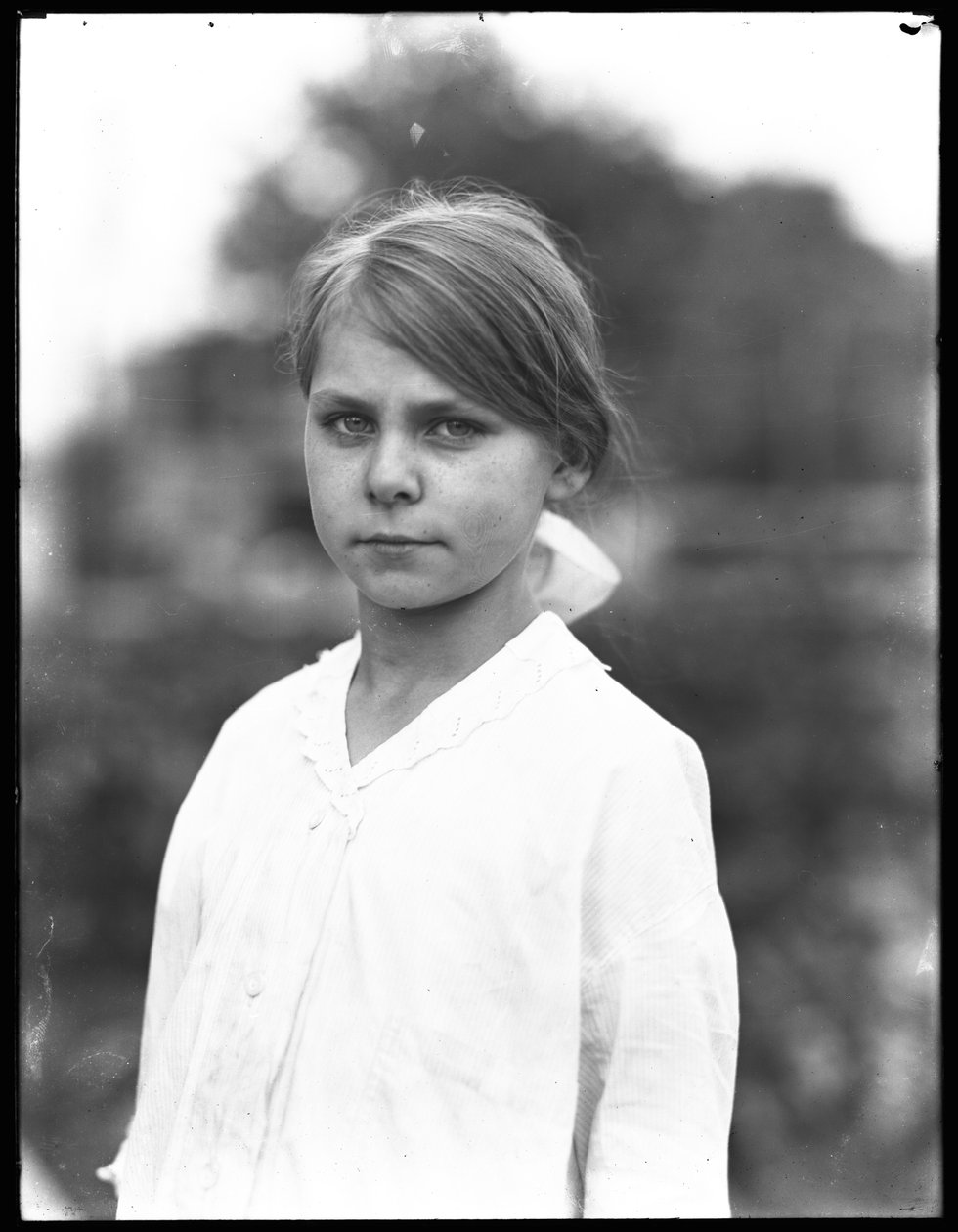 Utendørsportrettbilde av en uidentifisert liten jente i en hvit kjole, juli 1915 av William Davis Hassler