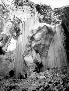 Gravemaskiner i arbeid langs en bratt vegg i et marmorbrudd i Apuan-alpene, Toscana. (s/hvitt bilde)